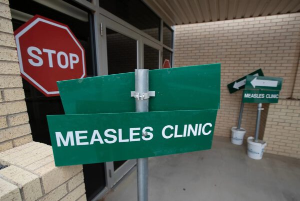 Directional sign for a measles clinic outside a building in rural Texas, highlighting the local response to a measles outbreak.